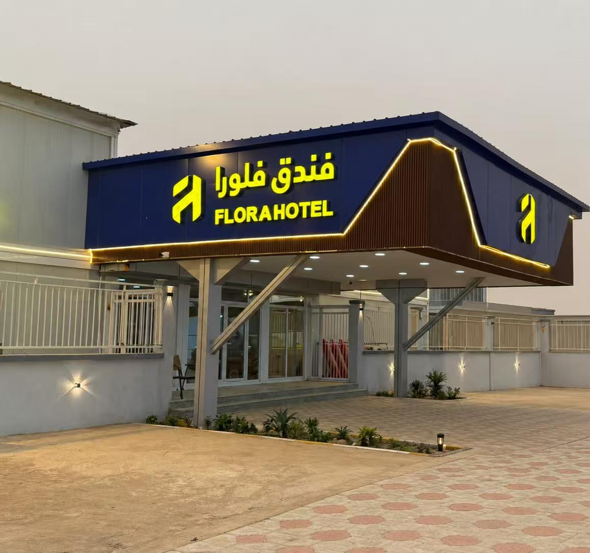 Flora Hotel entrance at dusk with illuminated facade