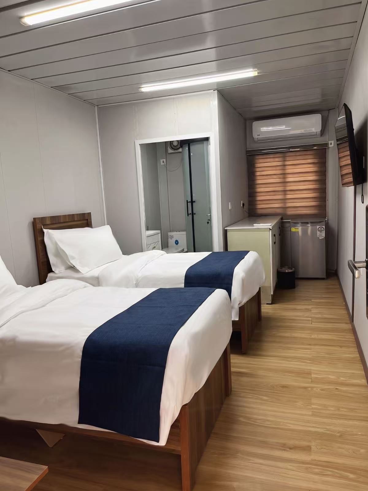 Guest room with en-suite bathroom partition, A/C and mini fridge